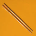 pair of momofuku chopsticks on orange background